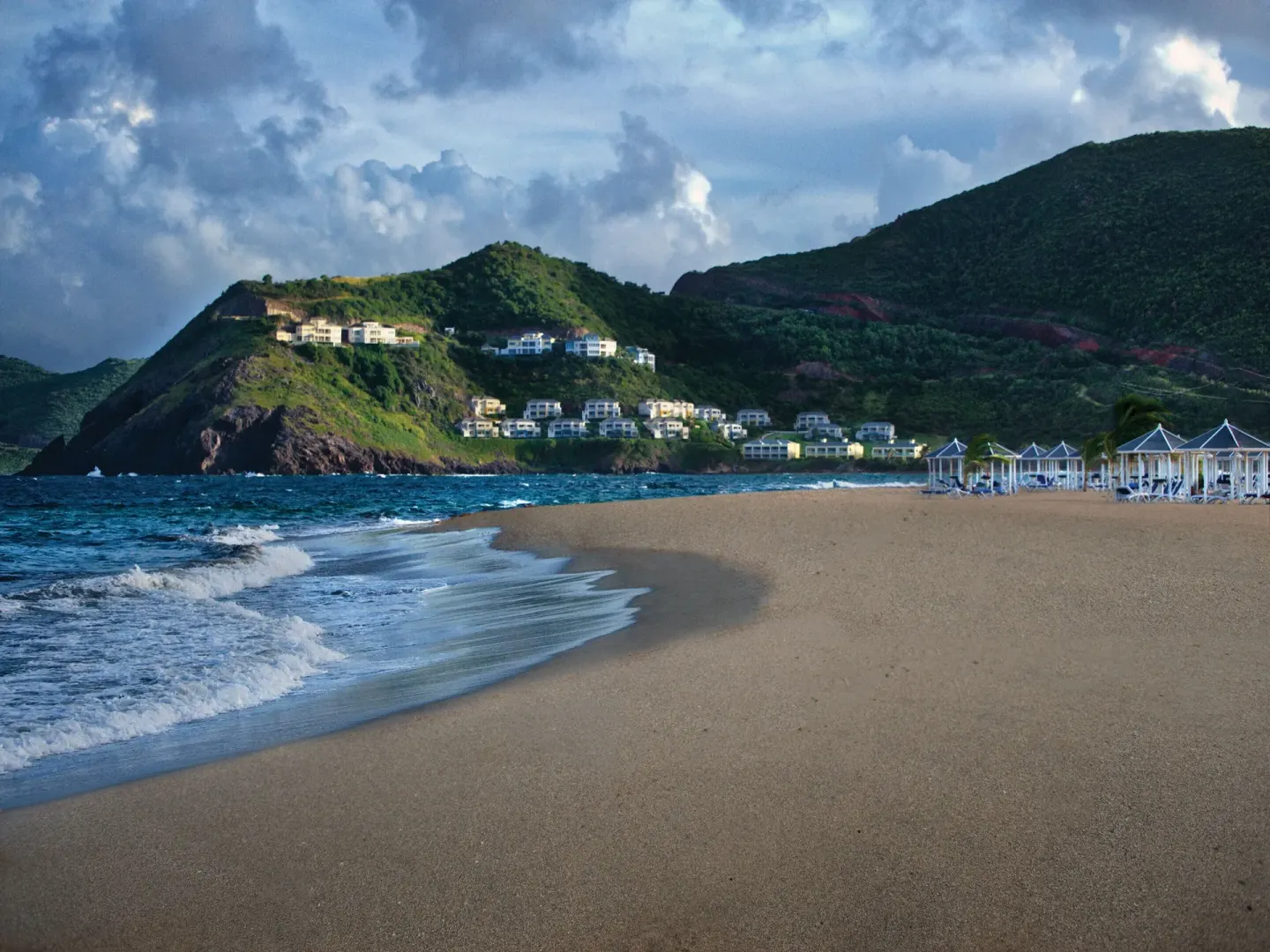 Sandy beach with surf and green hills near Marriott's St. Kitts Beach Club.