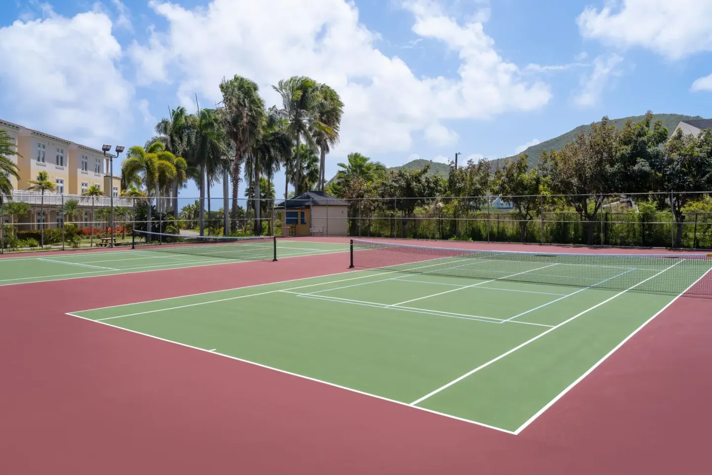 Tennis courts with palms and hills at Marriott's St. Kitts Beach Club.