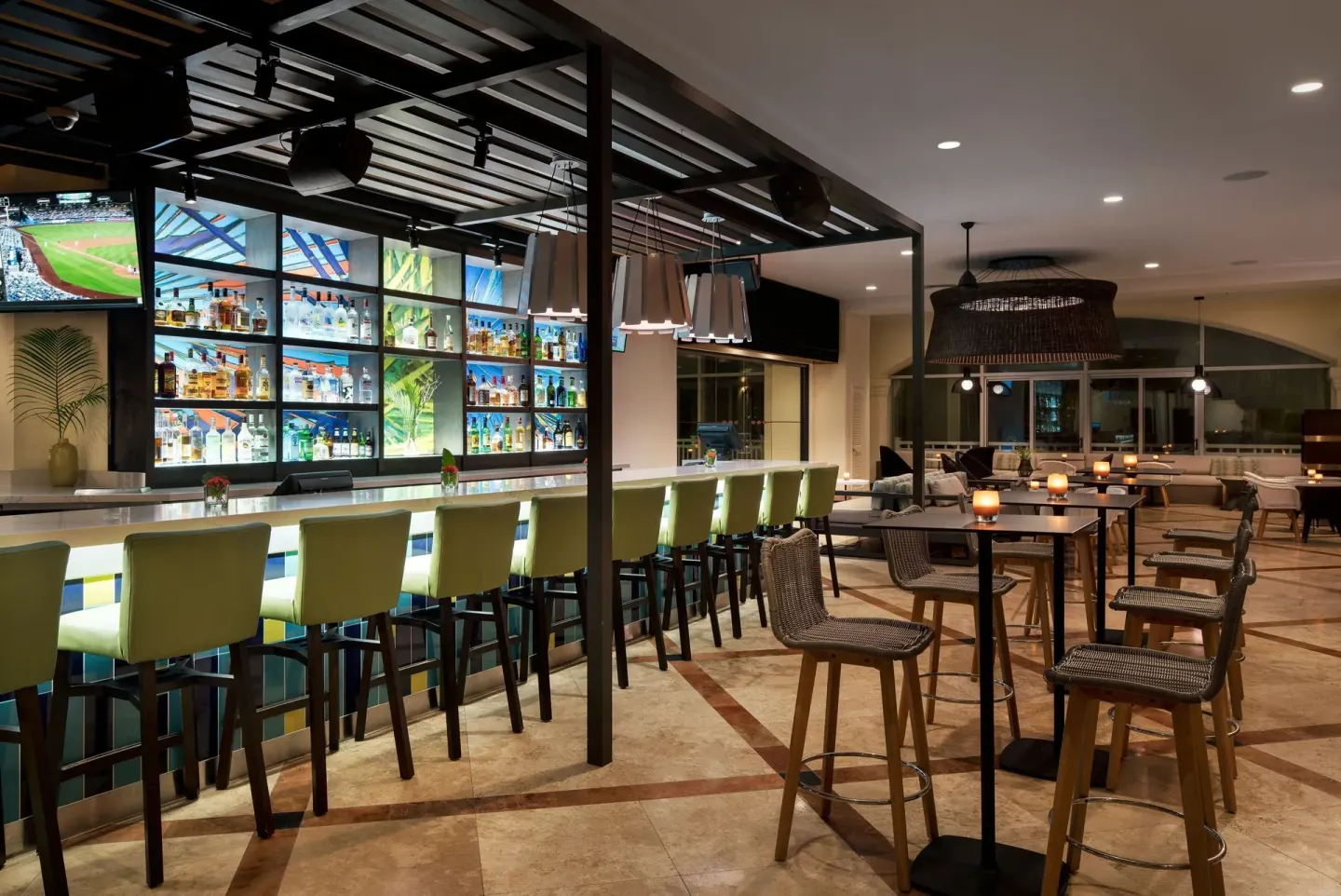 Bar with illuminated shelves and high tables at Marriott's St. Kitts Beach Club.