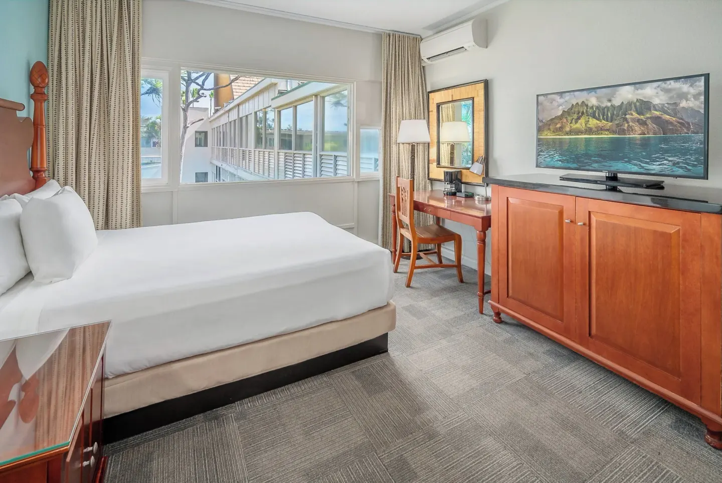 King bed guest room with desk and TV at Maui Beach Hotel.