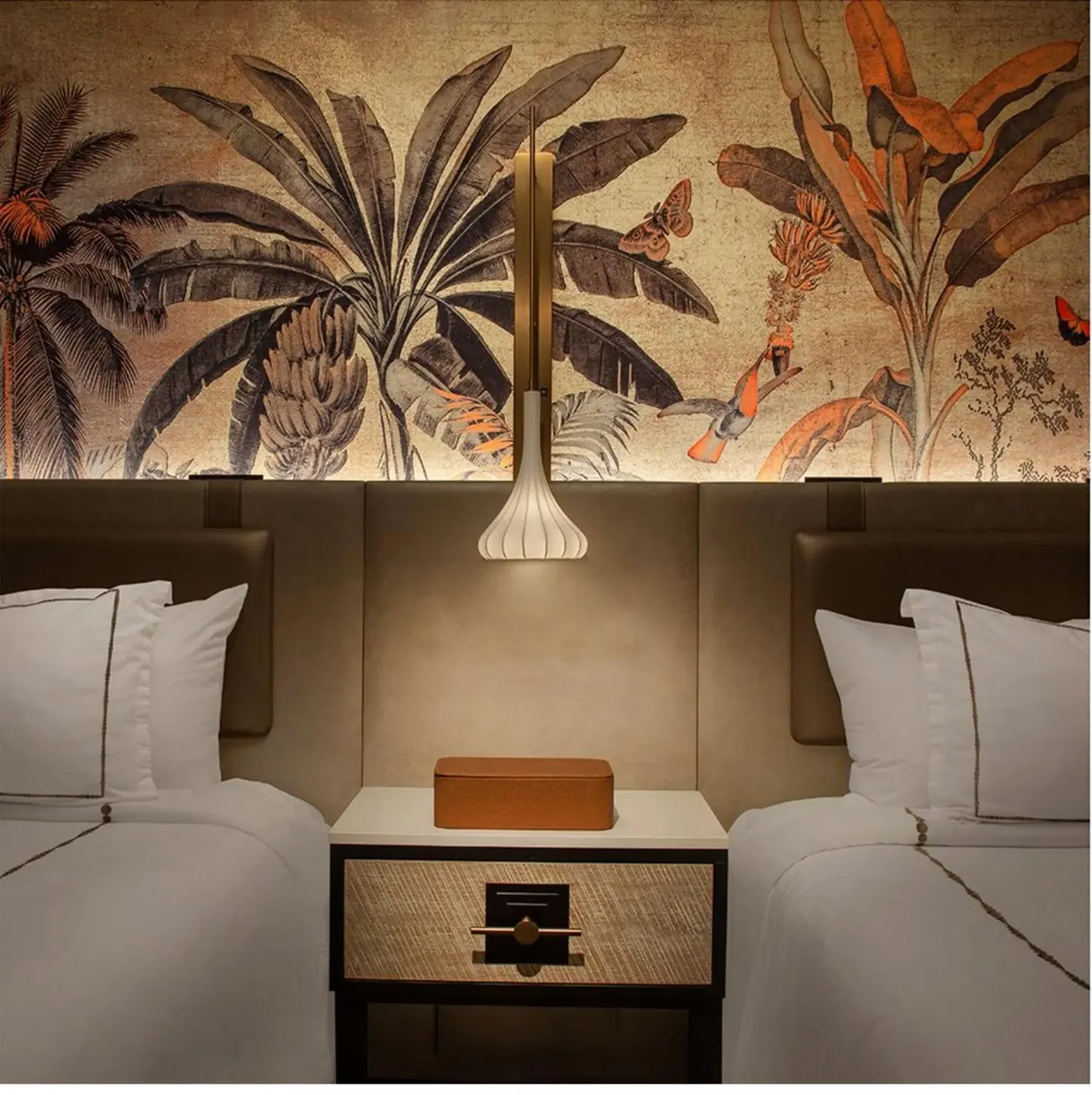 Two guest room beds with tropical mural and pendant lamp at Maui Seaside Hotel.