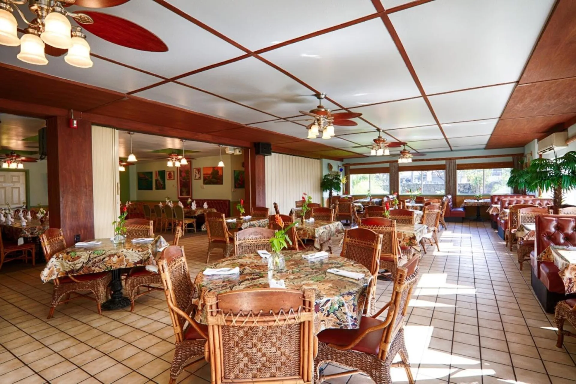 Dining room with wicker chairs and patterned tablecloths at Maui Seaside Hotel.