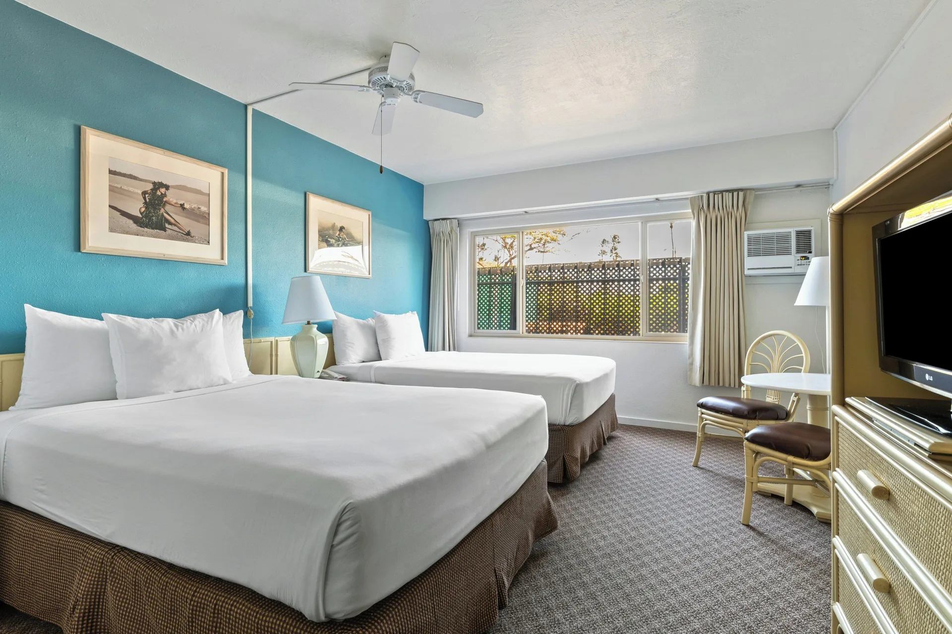 Standard Room with two beds, large window and TV dresser at Maui Seaside Hotel.