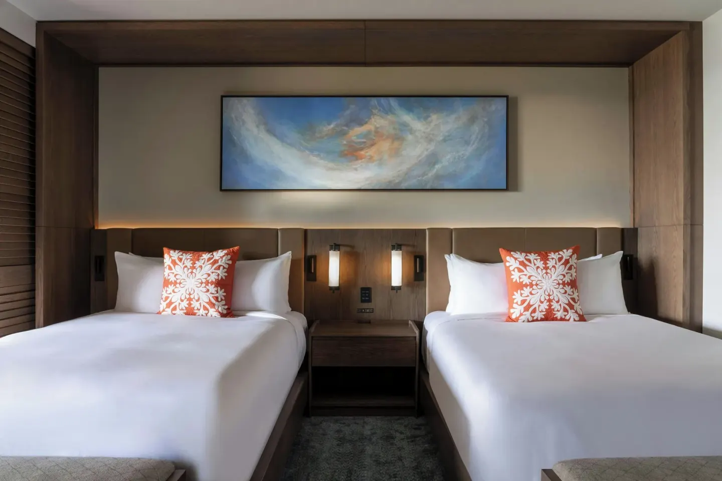 Two-bed beachfront room with wall art and bedside lighting at Mauna Kea Beach Hotel.