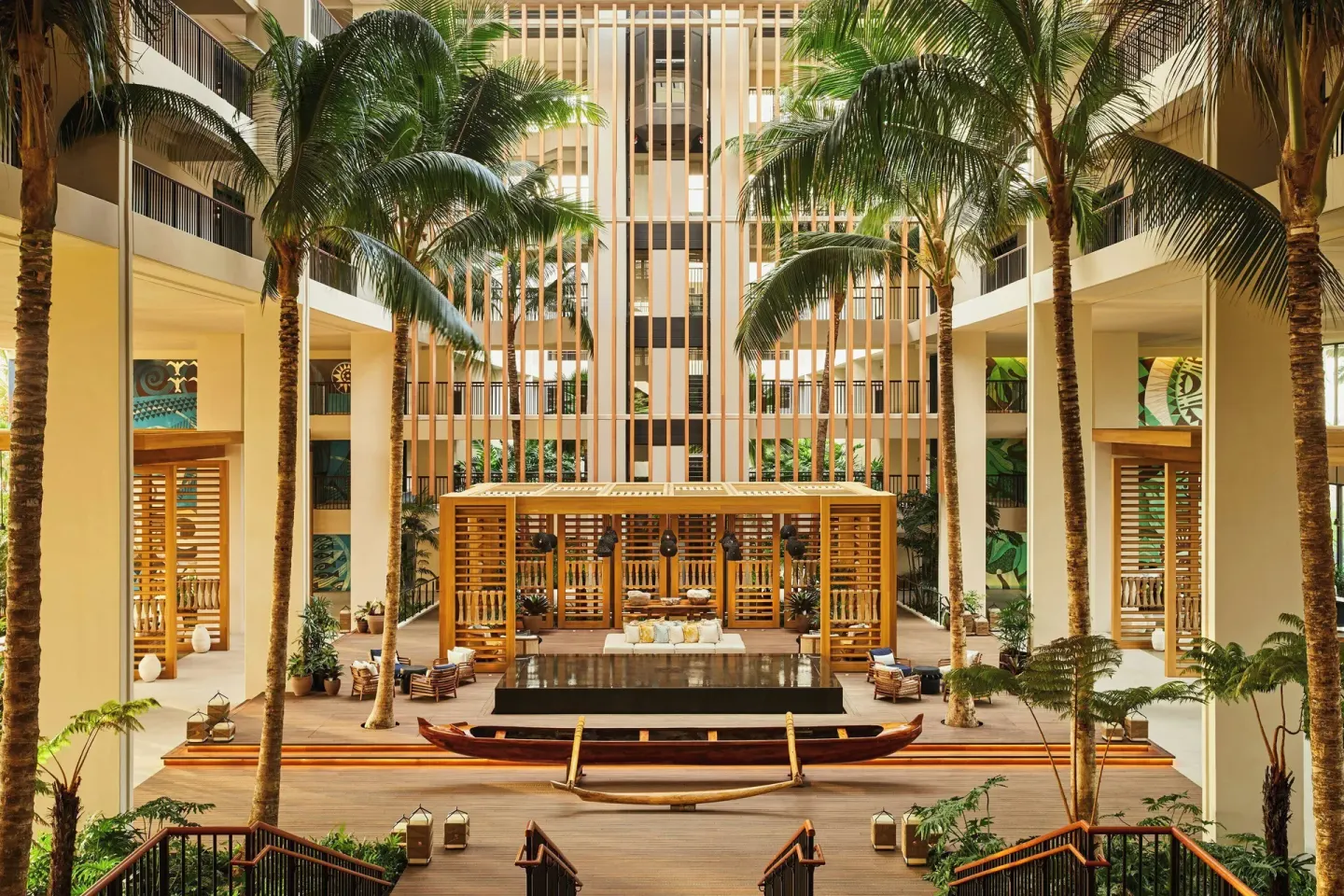 Atrium lobby with palm trees, a reflecting pool, and an outrigger canoe at Mauna Lani.