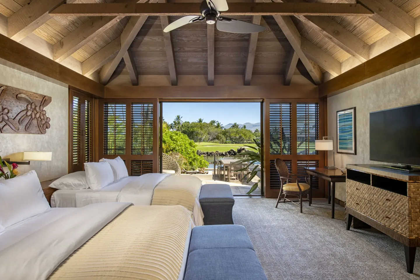 Two-bed bungalow room with open lanai doors and garden view at Mauna Lani.