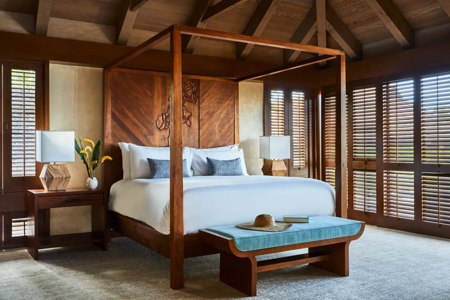 Four-poster king bed with wood shutters and vaulted ceiling at Mauna Lani.