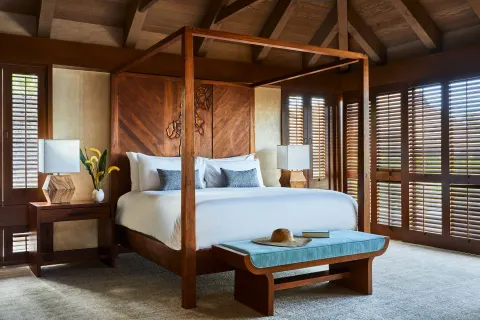 Four-poster king bed with wood shutters and vaulted ceiling at Mauna Lani.