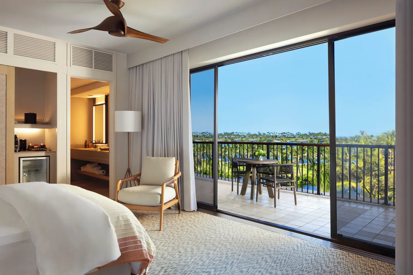 King bed guest room with lanai, wet bar, and landscape views at Mauna Lani.