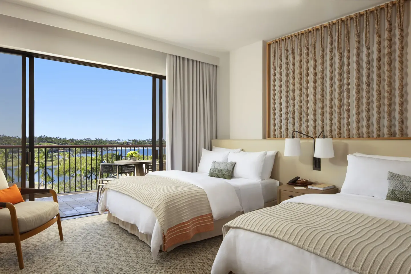 Two-bed guest room with balcony and water view at Mauna Lani.