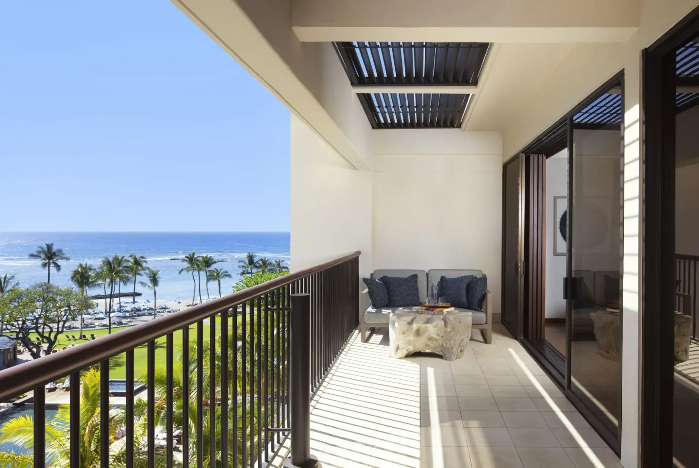 Covered balcony with lounge seating and a wide ocean view at Mauna Lani.