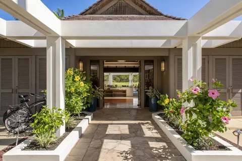 Resort entry walkway with hibiscus plants and open doors at Mauna Lani.