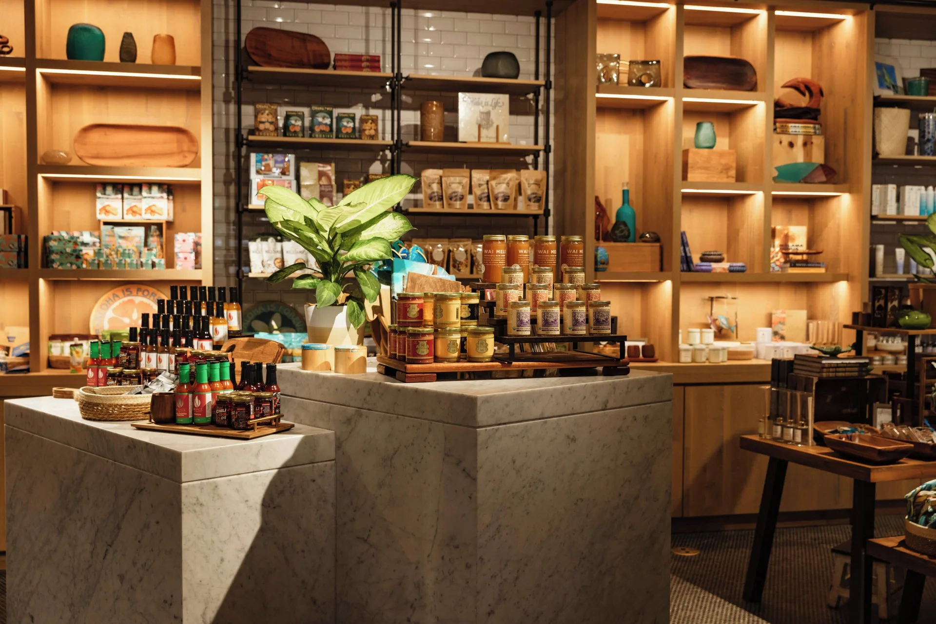Market shelves with packaged foods, gifts, and marble display tables at Mauna Lani.