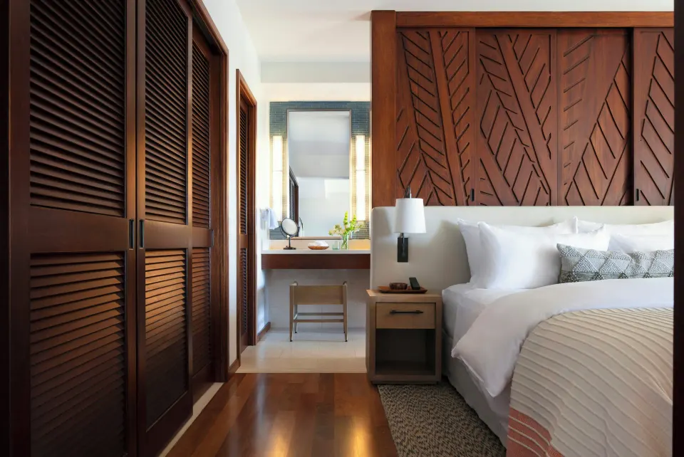 King bedroom with wood closets and vanity area in a Deluxe Suite at Mauna Lani.