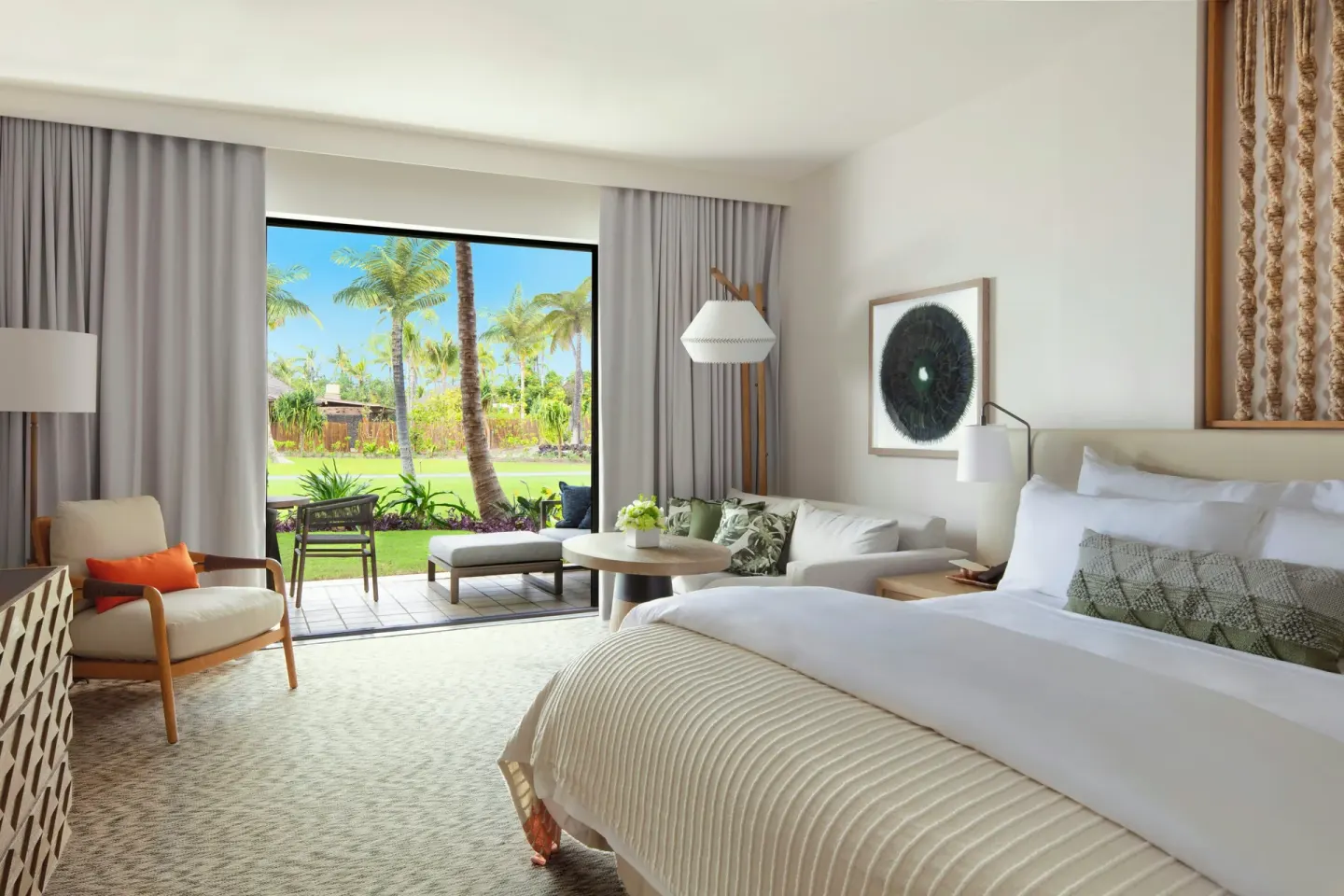 Garden View king room at Mauna Lani with a bed, seating area, lanai, and palm garden beyond.