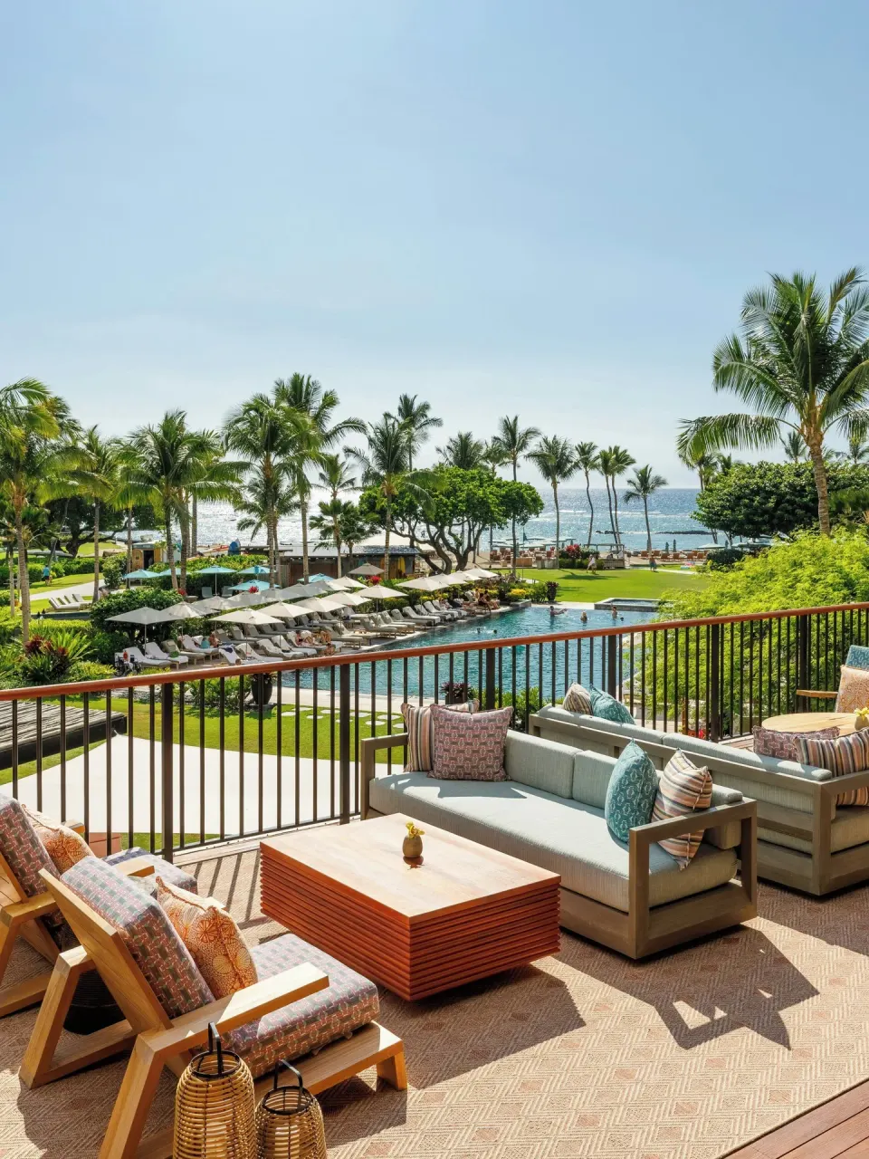 Oceanfront club lounge terrace at Mauna Lani overlooking the pool, palms, lawn, and ocean.