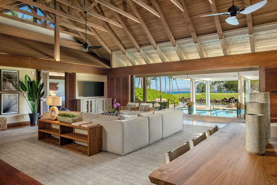 Ocean-view villa living and dining space at Mauna Lani with open doors to a pool terrace.