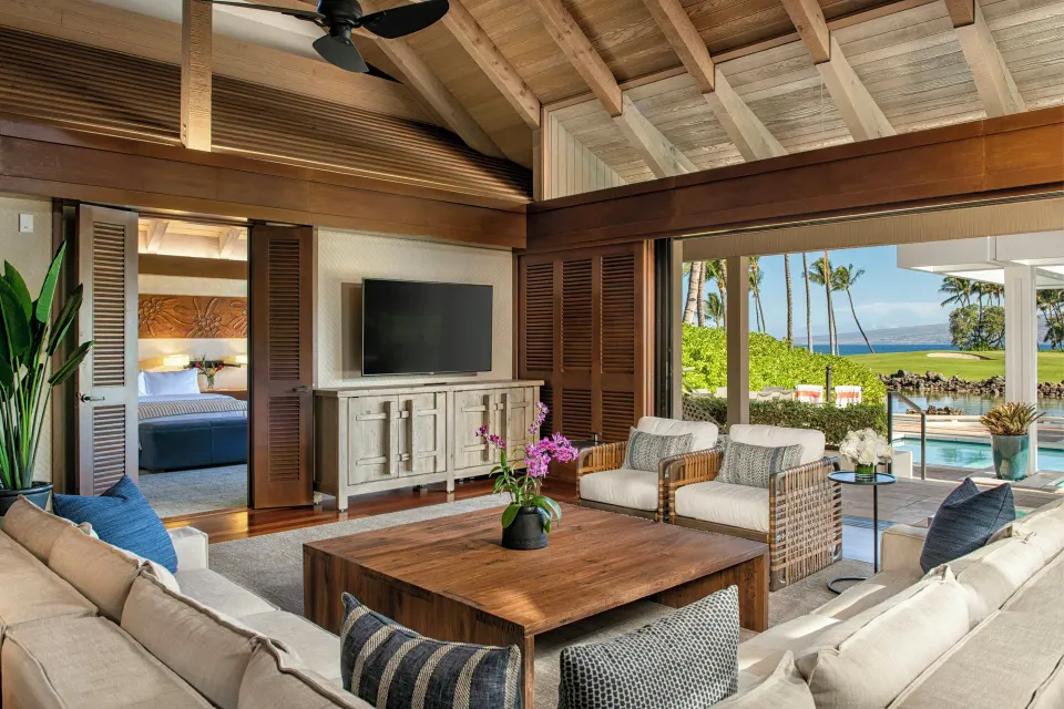 Villa lounge at Mauna Lani with cushioned seating, TV, and open view to the pool terrace.
