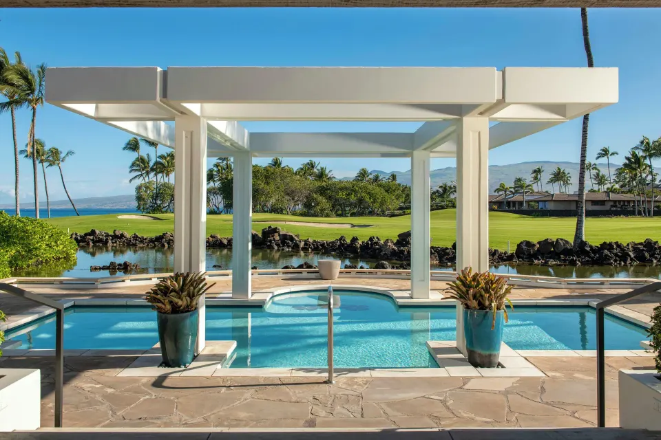 Private pool terrace of an ocean-view villa at Mauna Lani overlooking lawn, palms, and ocean.