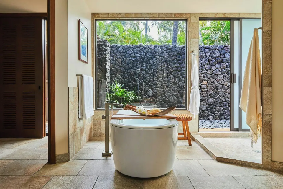 Oceanfront two-bedroom villa bathroom with soaking tub and outdoor shower area at Mauna Lani.