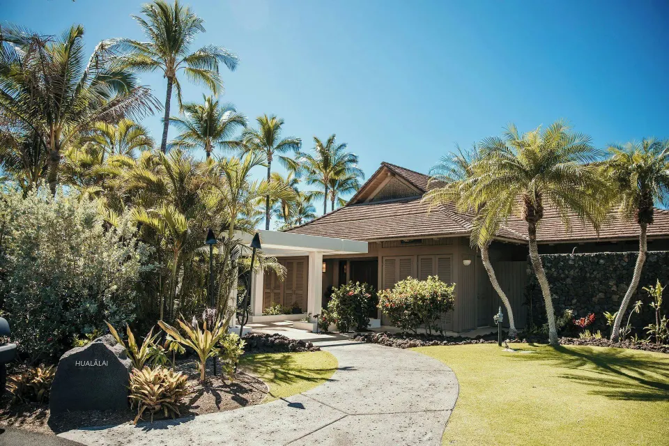Oceanfront villa entrance with tropical landscaping and palms at Mauna Lani.