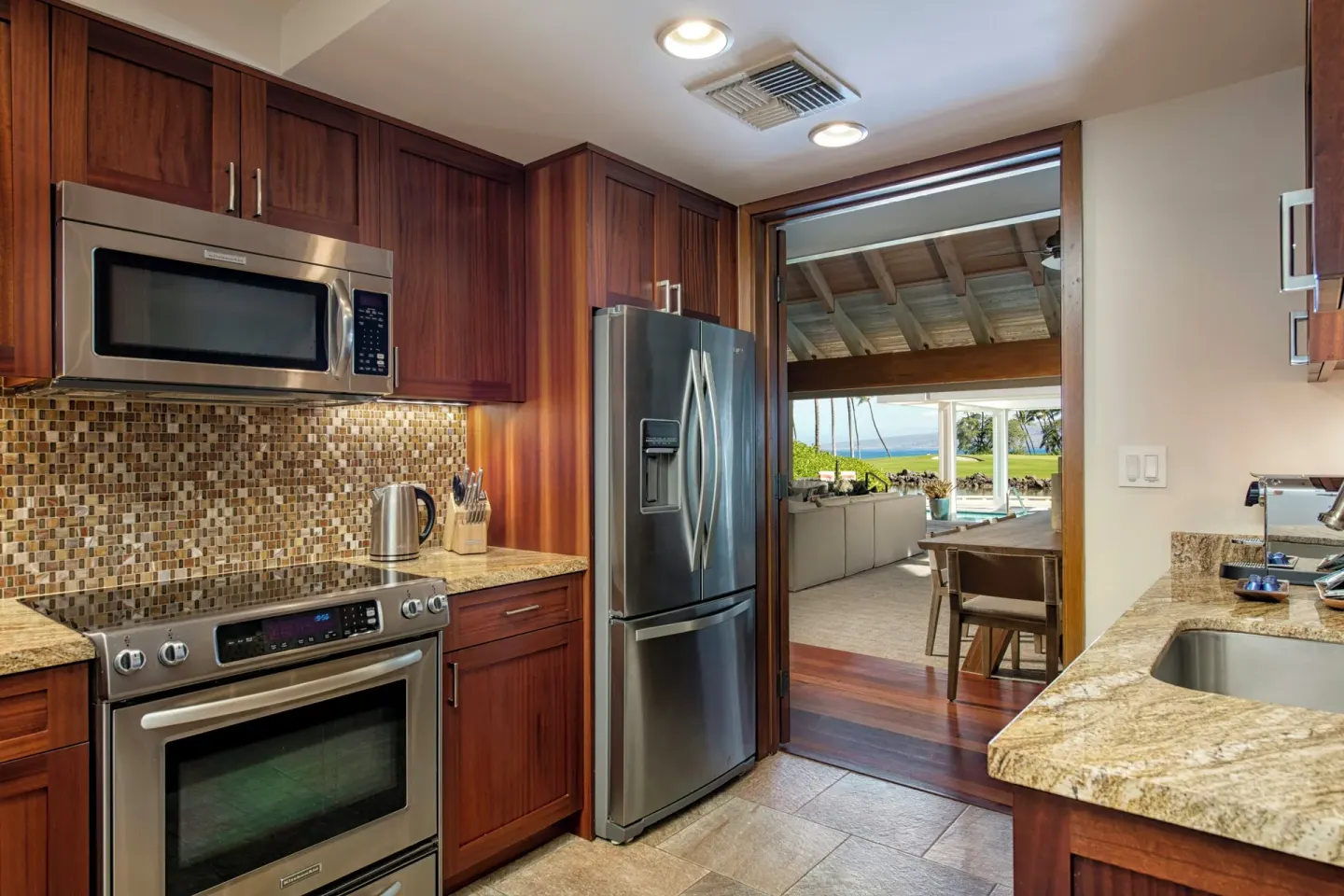 Oceanfront two-bedroom villa kitchen with wood cabinetry and stainless appliances at Mauna Lani.