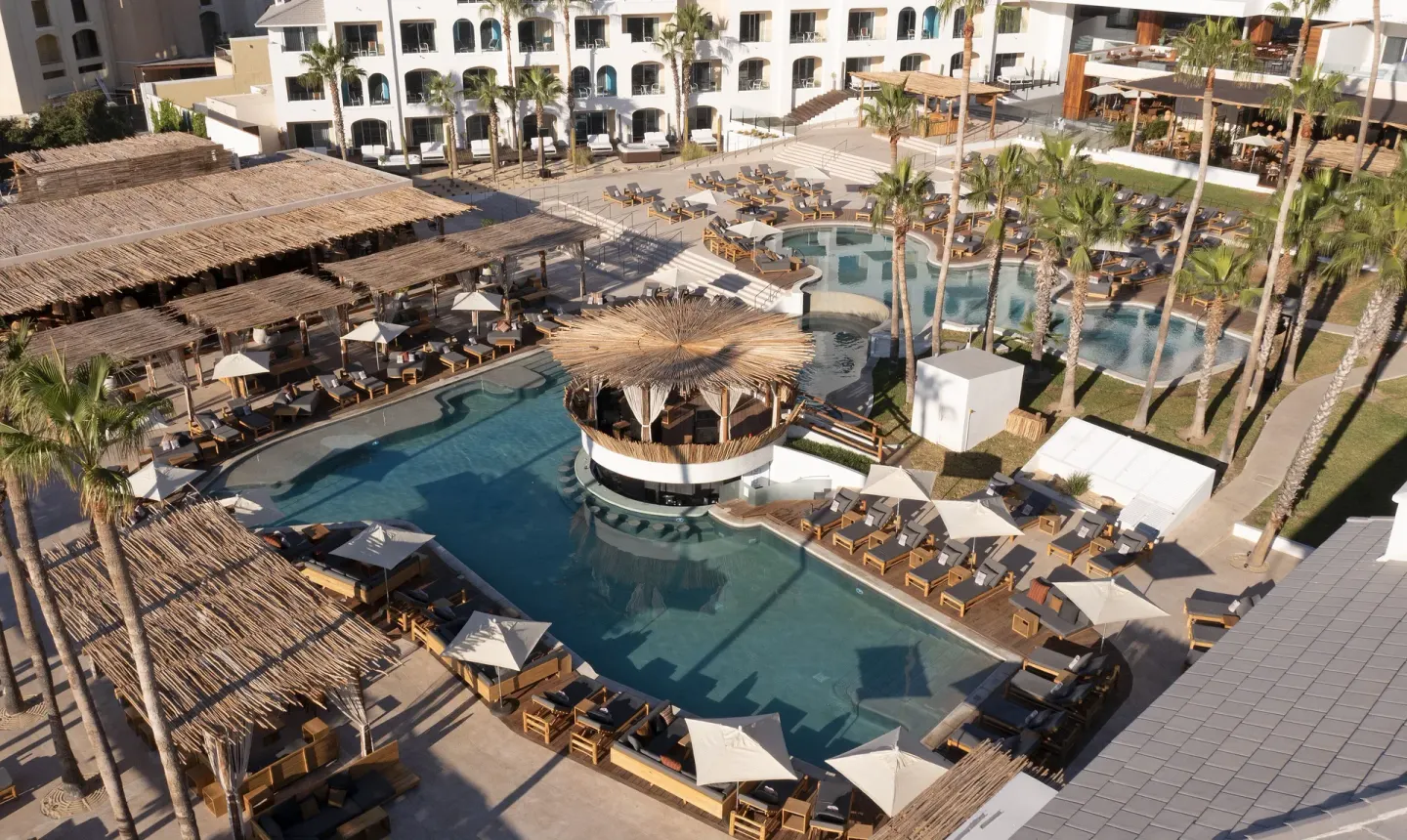Aerial view of the pool deck with loungers and palapa shade at ME Cabo.