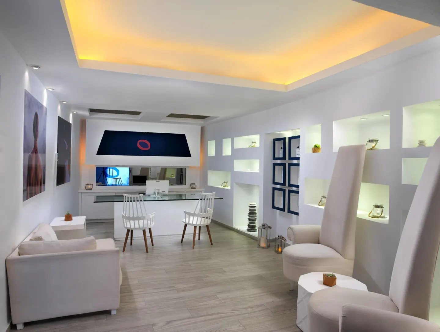 White lounge and reception area with illuminated wall niches at ME Cabo.