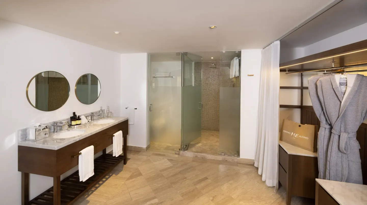 Exclusive ME+ Suite bathroom with double vanity, shower, and closet at ME Cabo.
