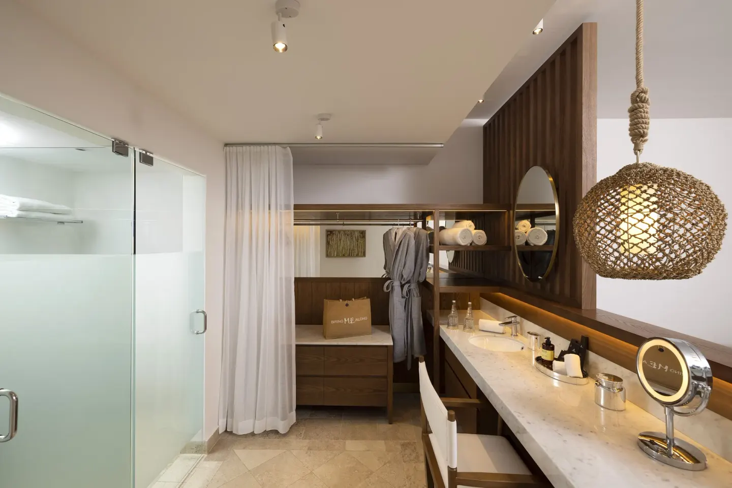 Extra ME+ Junior Suite vanity, glass shower, robe, and open closet at ME Cabo.