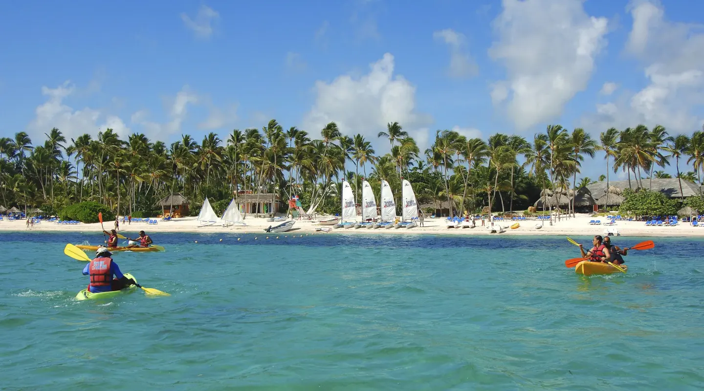 Kayakers paddle in turquoise water off the beach at Melia Caribe Beach Resort.