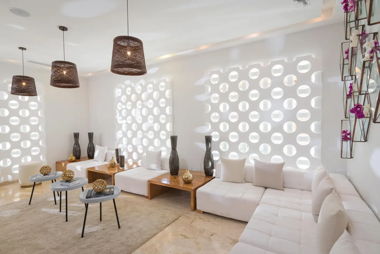 Bright lounge with white sofas and circular wall cutouts at Melia Caribe Beach Resort.