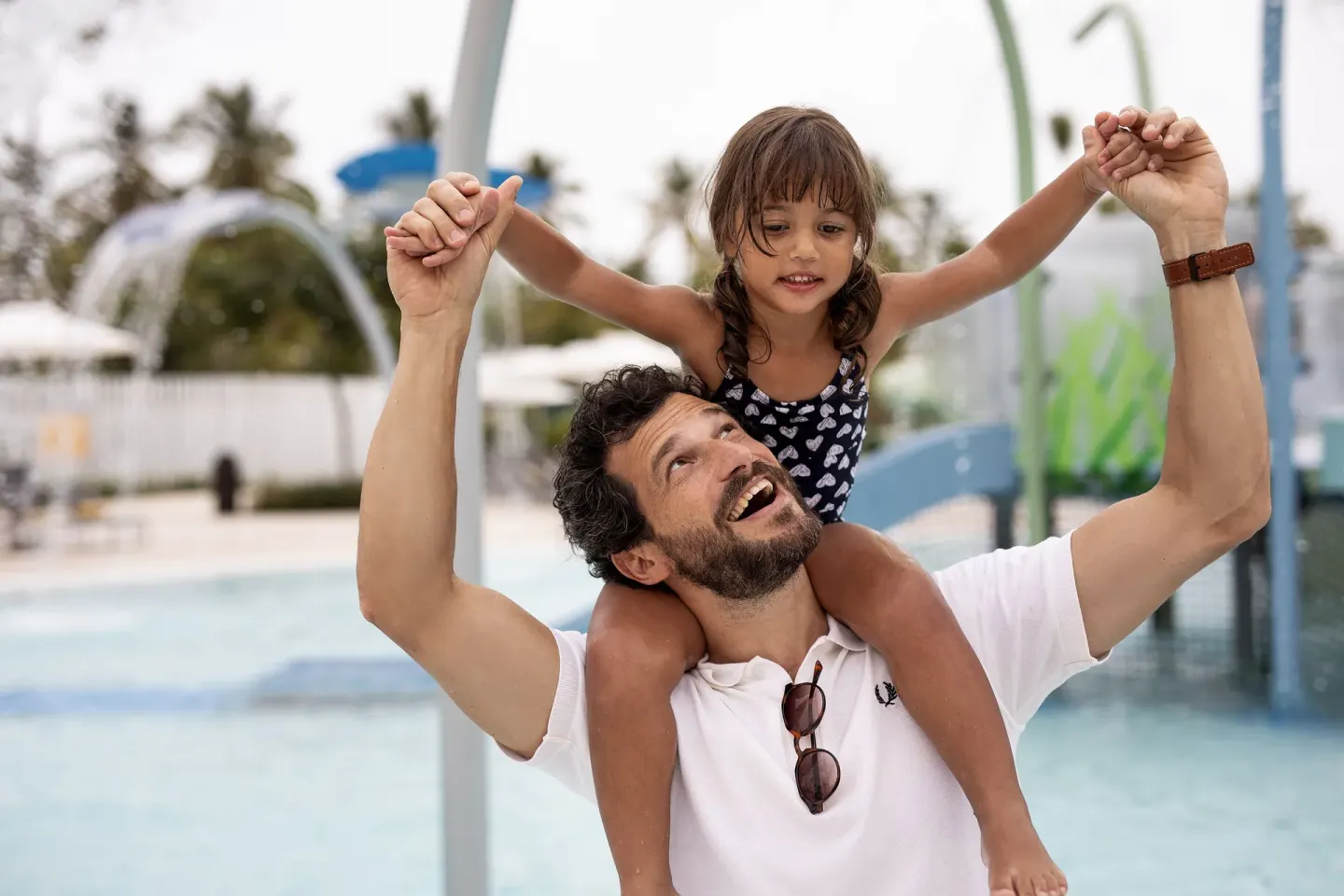 Adult carrying a child on his shoulders in the water play area at Melia Caribe Beach Resort.