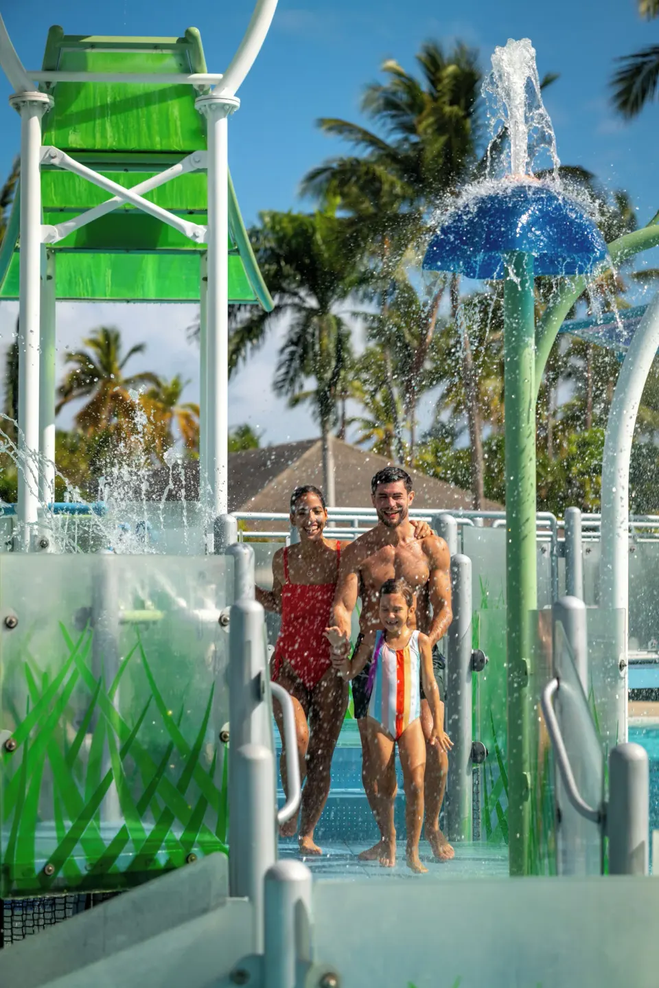 Family walking through splash features at the aqua park at Melia Caribe Beach Resort.