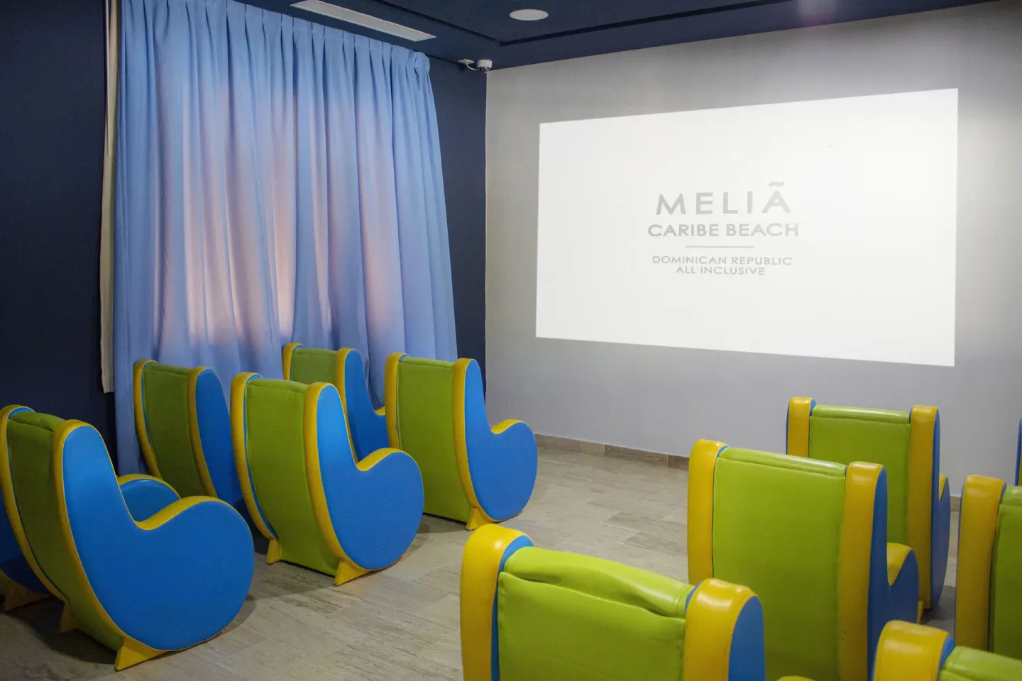 Kids cinema room with colorful seats and a projected screen at Melia Caribe Beach Resort.