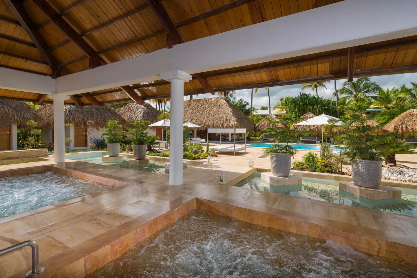 Open-air spa hydrotherapy pools under a wood roof at Melia Caribe Beach Resort.