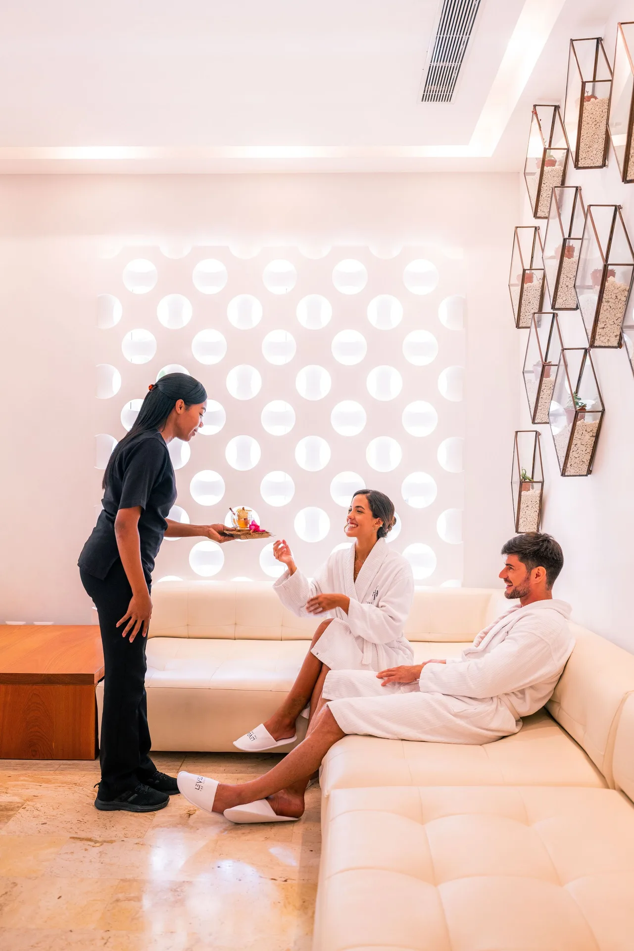 Spa attendant serves refreshments to guests in robes at Melia Caribe Beach Resort.