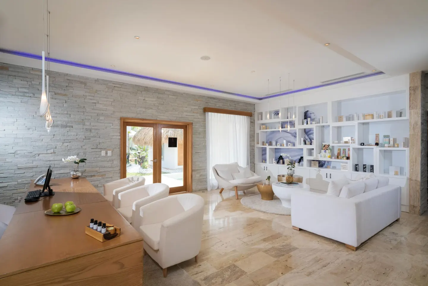 Spa reception lounge with white seating and product shelves at Melia Caribe Beach Resort.