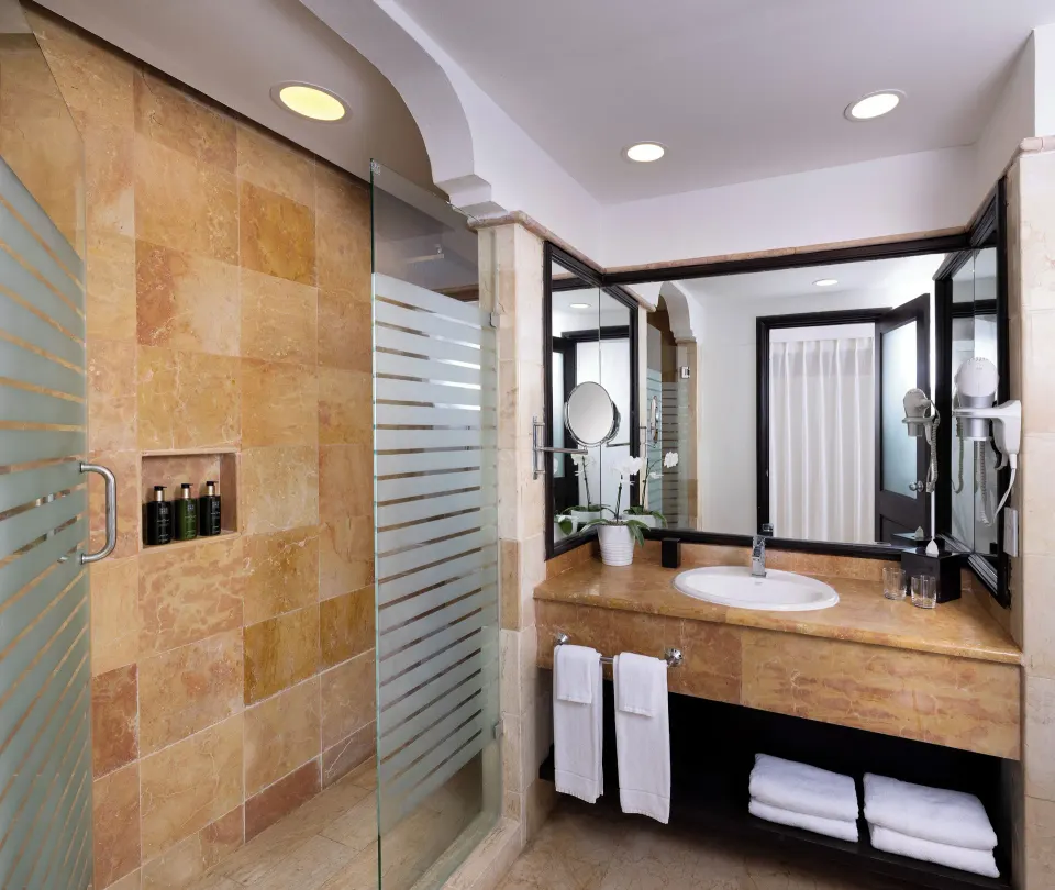 Deluxe Room bathroom at Melia Caribe Beach Resort with glass shower and vanity.