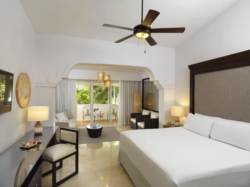 Deluxe Room king bed and sitting area at Melia Caribe Beach Resort with balcony beyond.