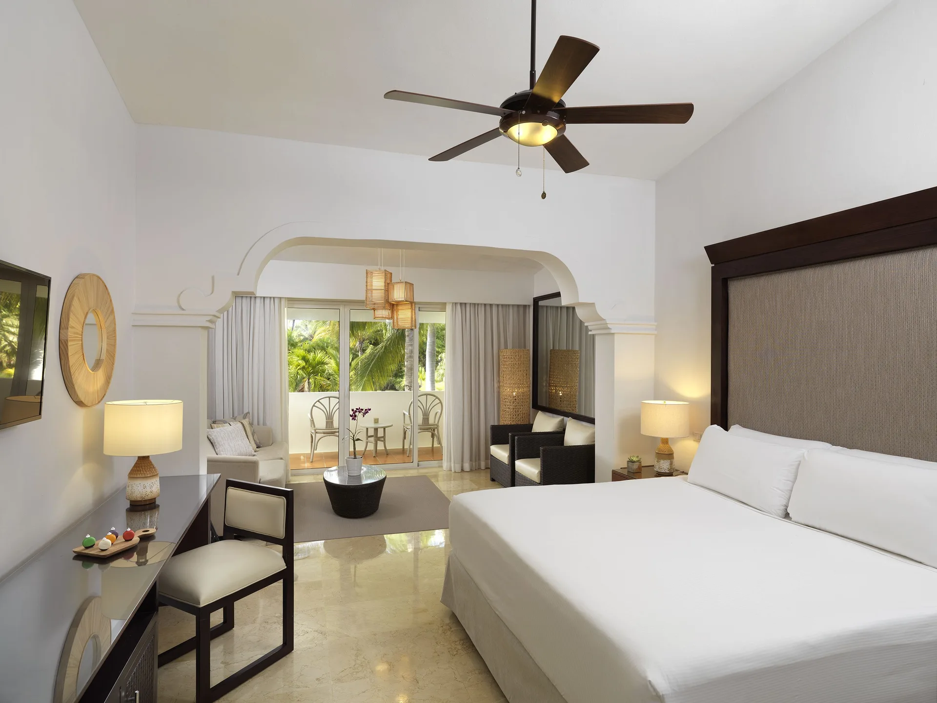 Deluxe Room king bed and sitting area at Melia Caribe Beach Resort with balcony beyond.
