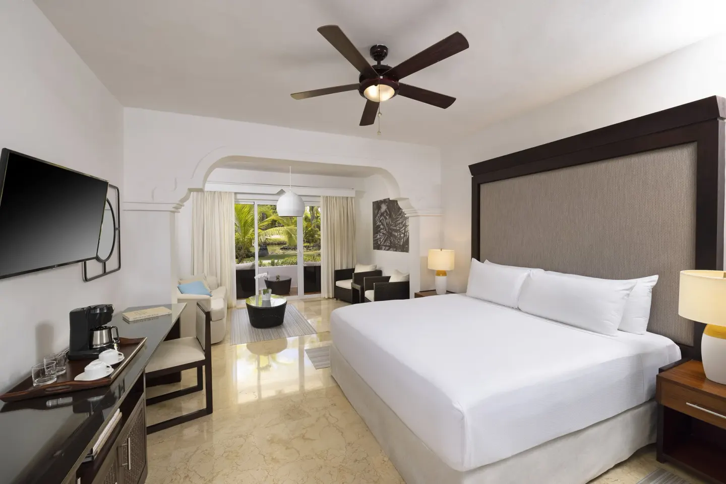Deluxe Room king bed at Melia Caribe Beach Resort with TV, coffee station, and lounge area.