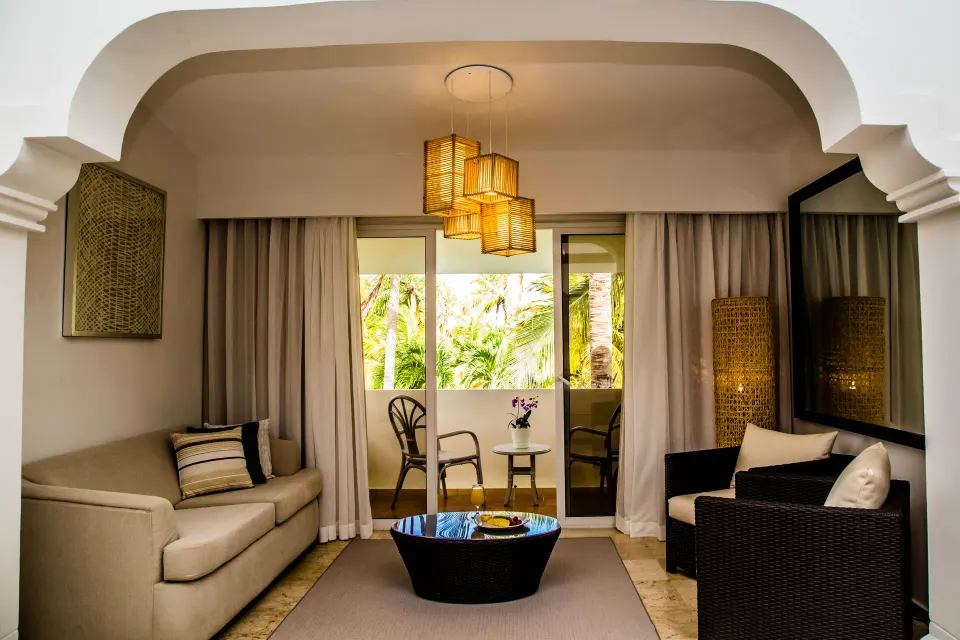 Deluxe Room sitting area and balcony at Melia Caribe Beach Resort with palm views.