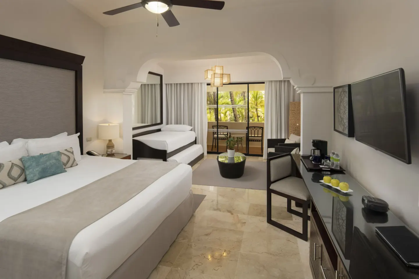 Family Room Tropical Palms with beds and balcony at Melia Caribe Beach Resort.