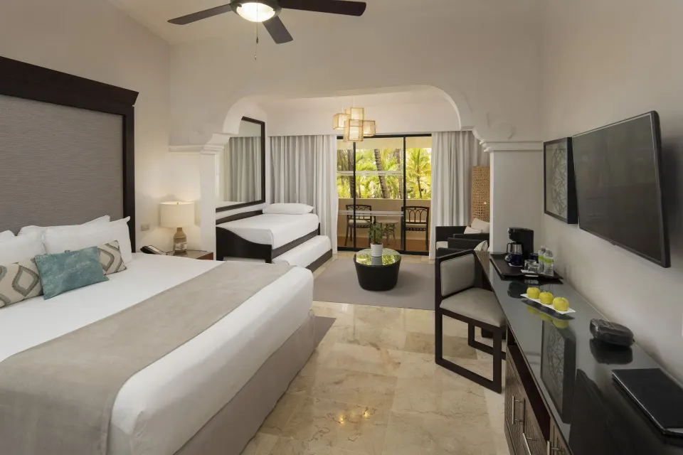 Family Room Tropical Palms with beds and balcony at Melia Caribe Beach Resort.