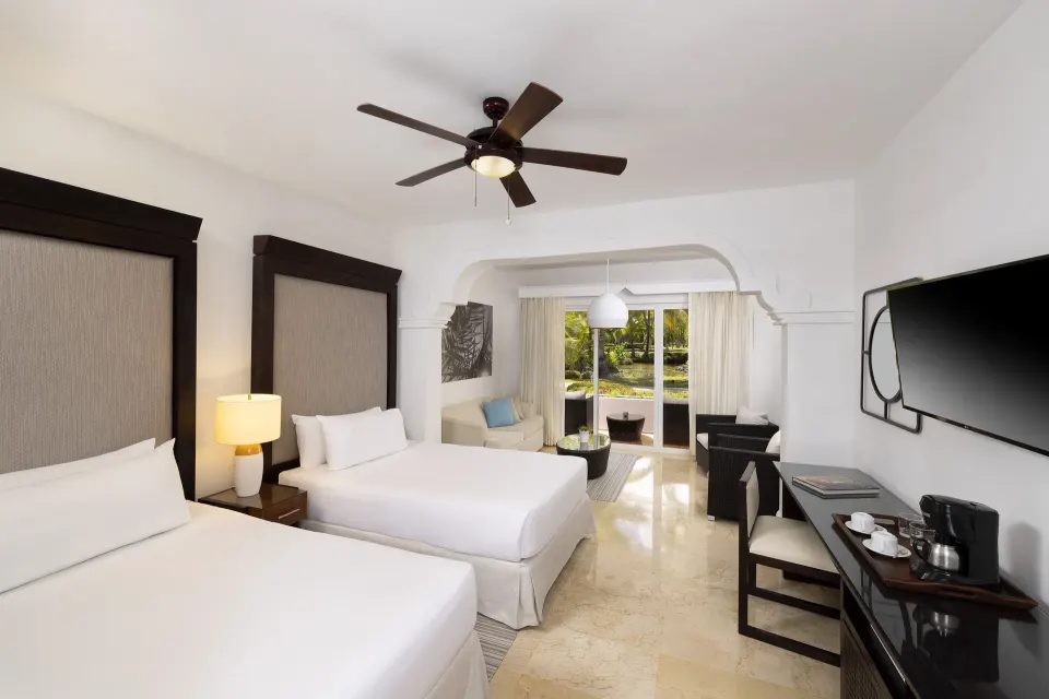 Two-bedroom suite with two beds and sitting area at Melia Caribe Beach Resort.