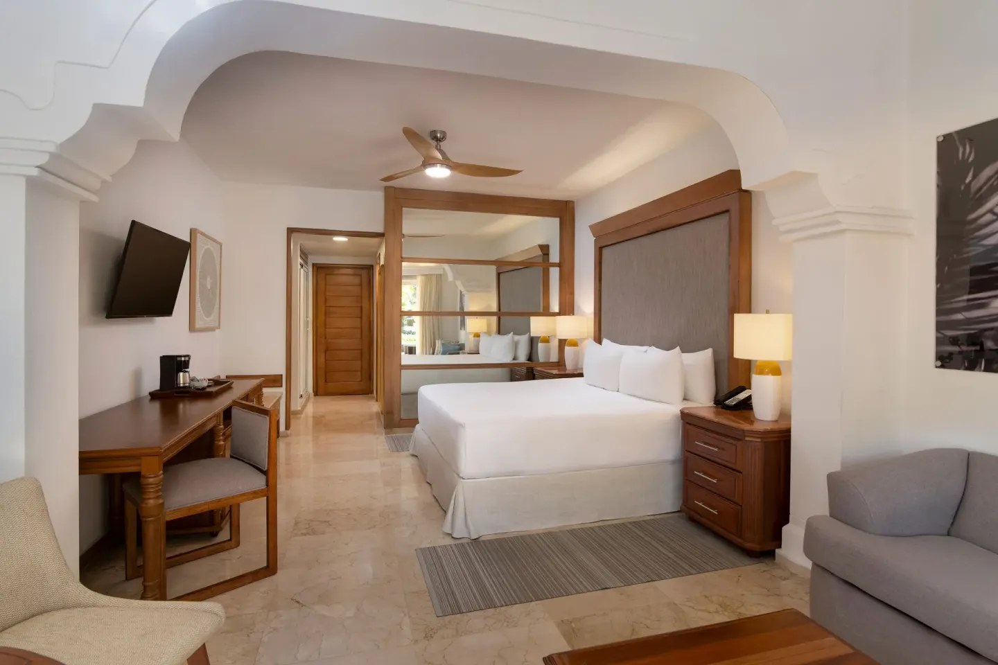 King bed, desk, and sofa area in The Level Junior Suite Garden View at Melia Caribe Beach Resort.