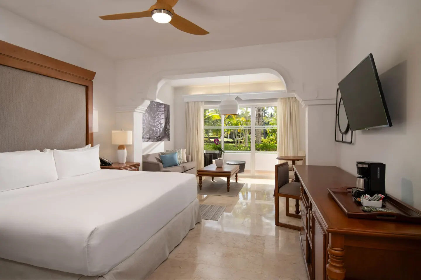 King bed and garden-facing sitting room in The Level Junior Suite Garden View at Melia Caribe Beach Resort.