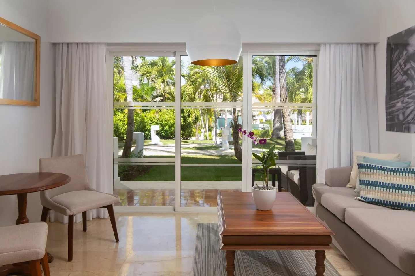 Garden-facing lounge with sofa and table in The Level Junior Suite Garden View at Melia Caribe Beach Resort.