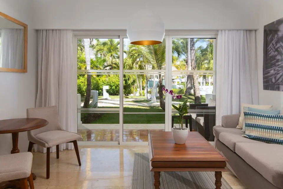 Garden-facing lounge with sofa and table in The Level Junior Suite Garden View at Melia Caribe Beach Resort.